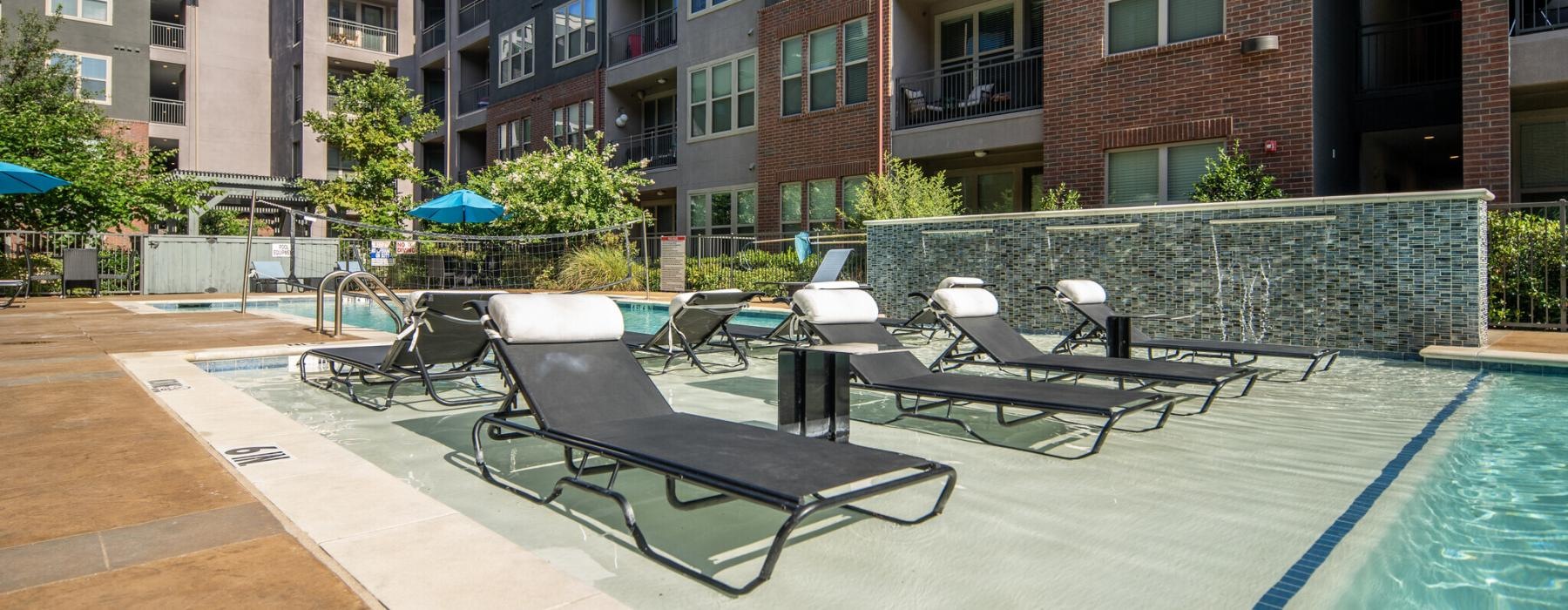 a pool and chairs by a building